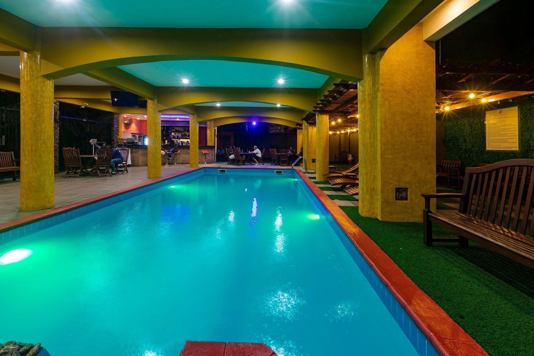 A long turquoise pool glowing at night